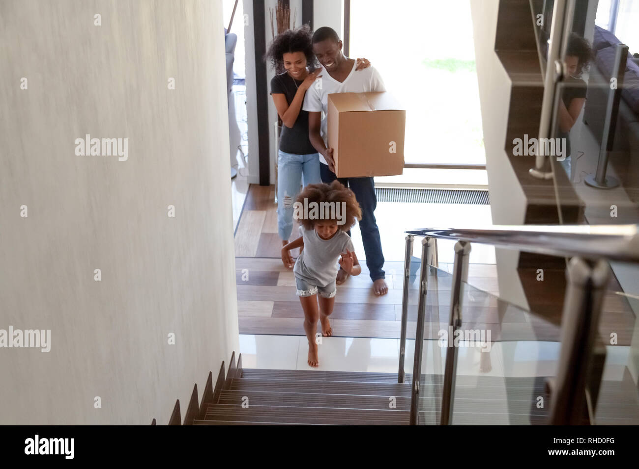 Bambino africano esplorare la nuova casa in movimento nella camera con i genitori Foto Stock