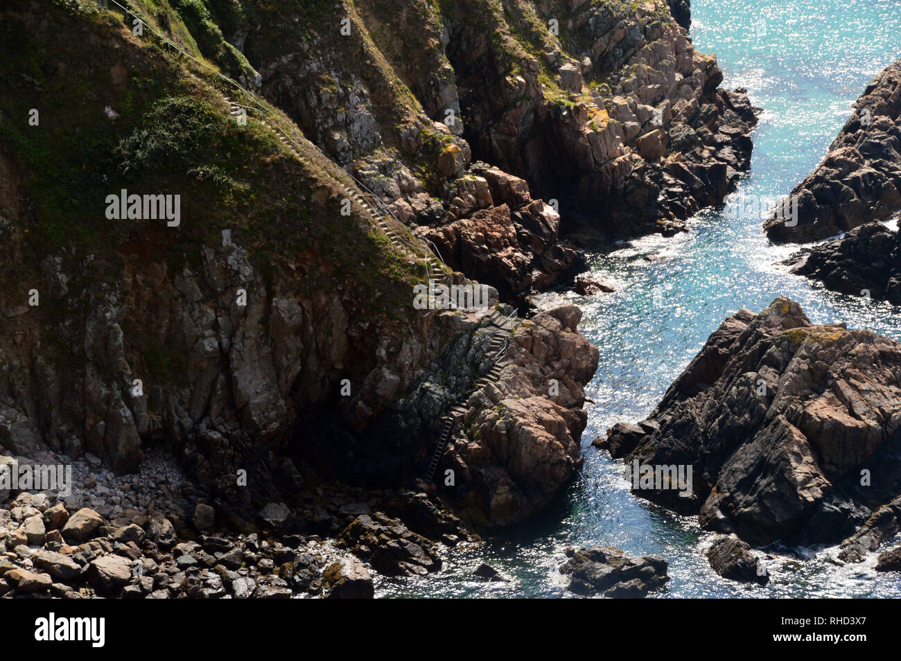 Il Concreate passaggi e la scala di metallo che conducono in basso verso la caletta rocciosa di Le Jaonnet Bay dal sentiero costiero in Guernsey, Isole del Canale.UK. Foto Stock