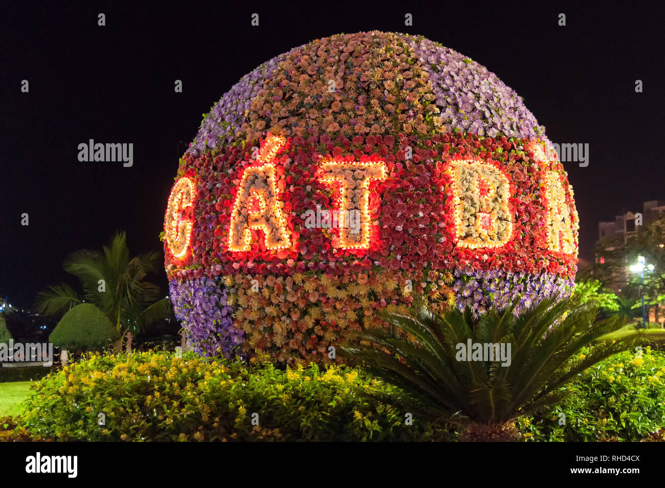 Un grande segno floreale con Cat Ba in luci di notte, Cat Ba town, la baia di Ha Long, Vietnam Foto Stock