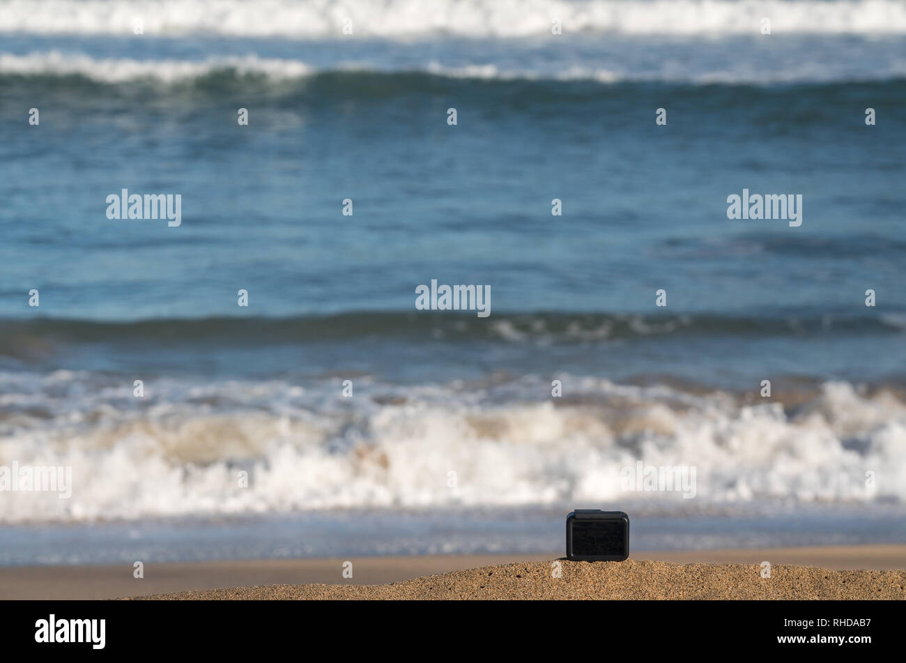 Fotocamera sulla spiaggia prendendo il timelapse di onde di laminazione Foto Stock