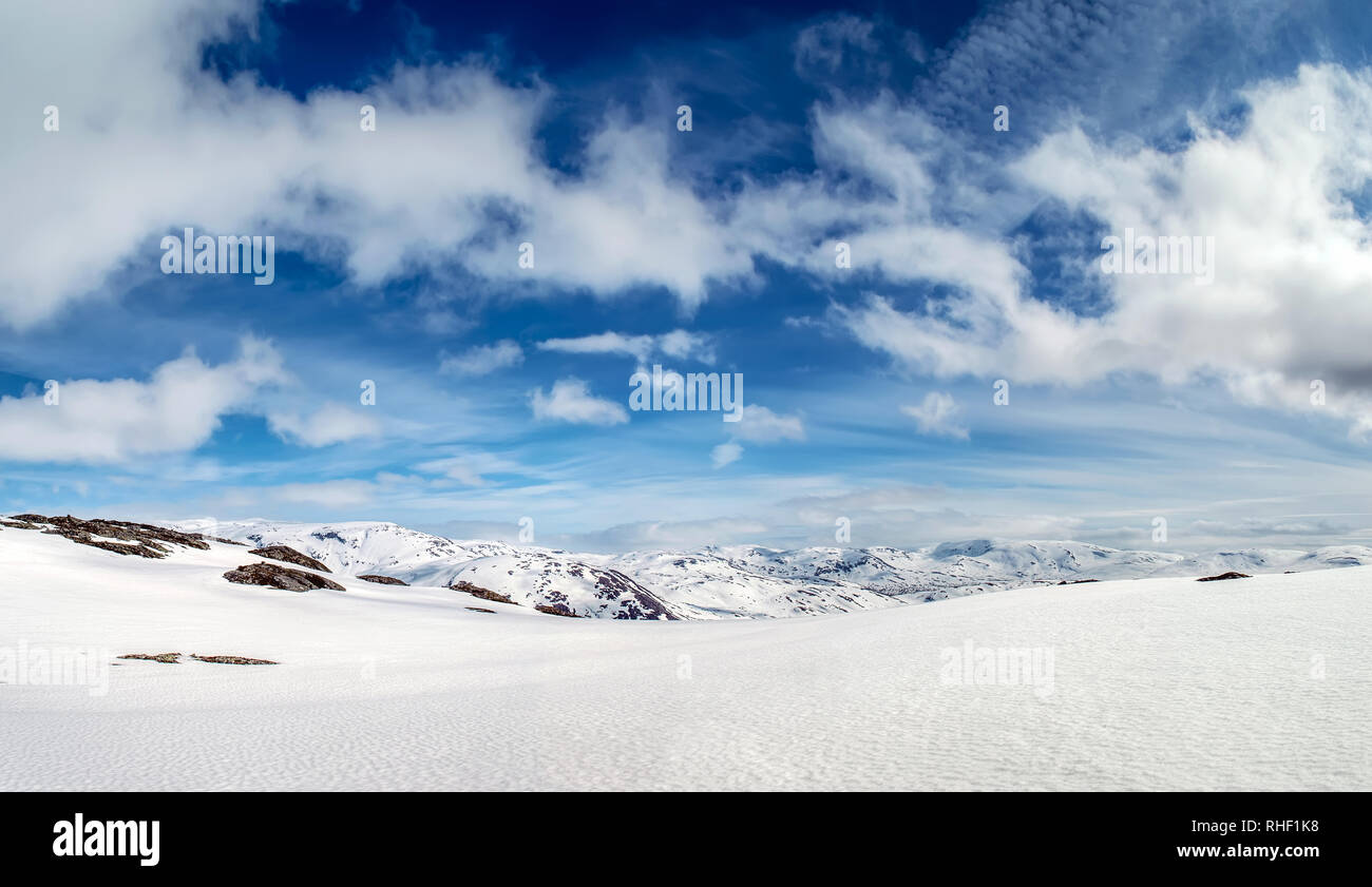 Vista panoramica del paesaggio di montagna. Bianco puro campo di neve. Cielo blu e nuvole bianche. La Norvegia. Foto Stock