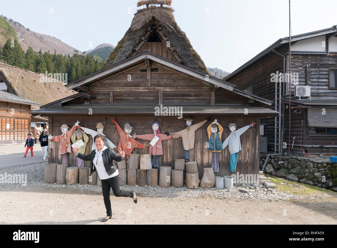 Tourist pone di fronte ad una tradizionale casa colonica nel villaggio di Ogimachi, Shirakawa-go, Giappone Foto Stock