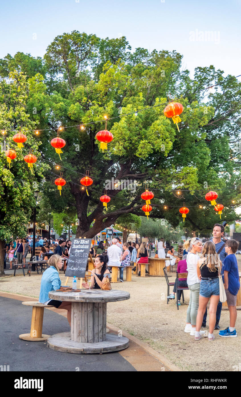 La gente seduta e a mangiare e a bere sotto Chinesered lanterne su Fringe Festival Mondiale Russell Square Northbridge WA Perth Australia. Foto Stock