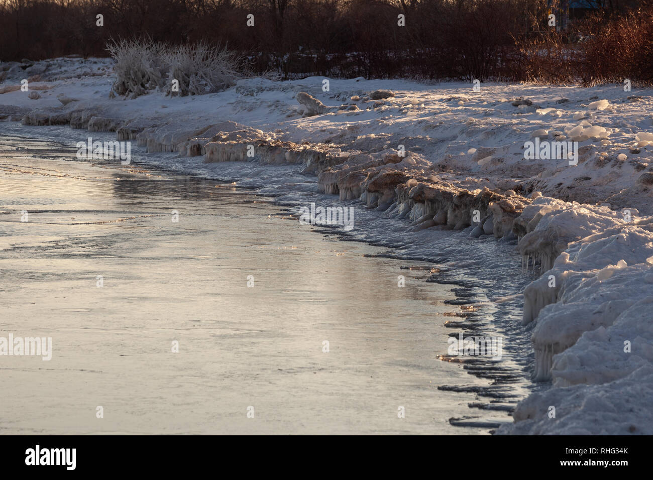 Panoramica invernale canadese paesaggio vicino a Toronto, bella congelato il lago Ontario al tramonto. Paesaggio di inverno alberi, acqua e cielo blu. Foto Stock