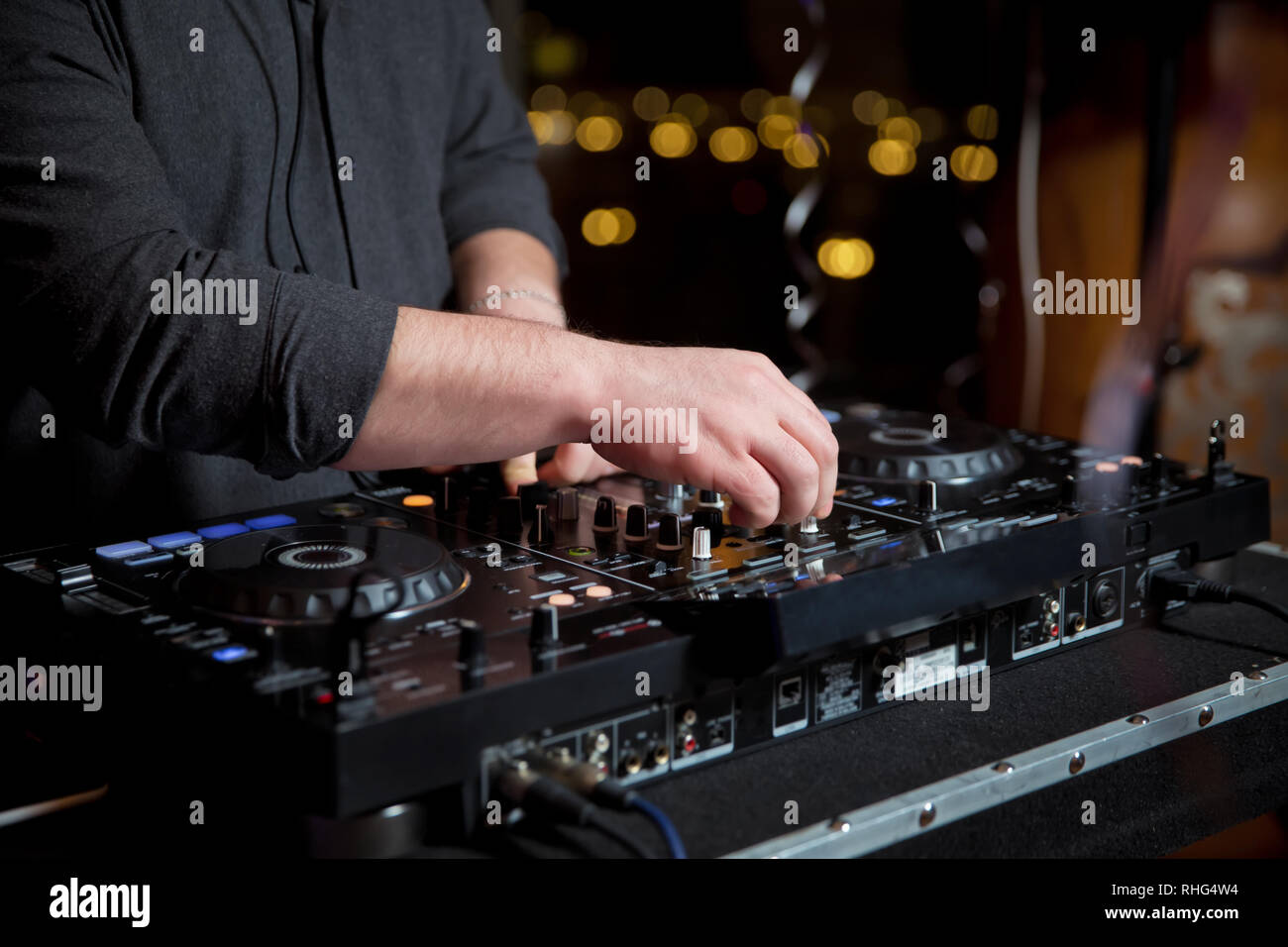 Disc jockey mixare musica sul digitale midi controller giradischi al hip hop party sul palco in night club.Mani di DJ giocare mostrano tracce di miscelazione in mescolatore su con Foto Stock