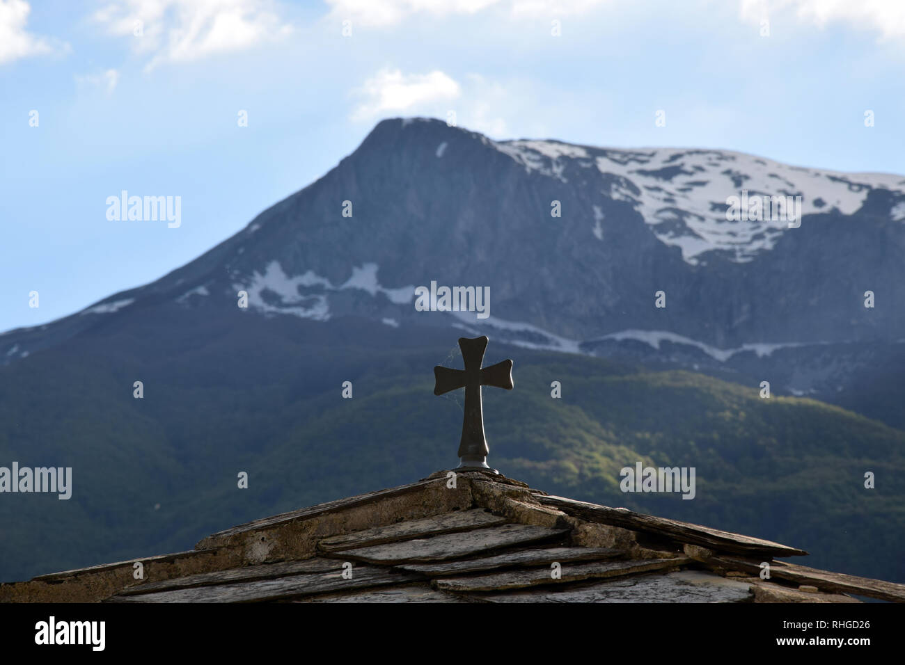 Una croce cristiana sul tempio del tetto con sfondo di montagna. La Macedonia. Foto Stock