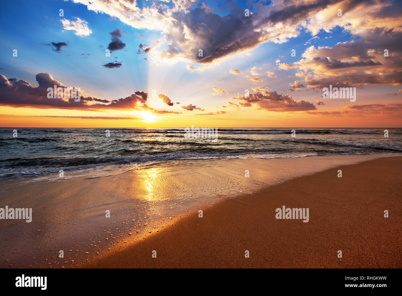 Colorata Ocean Beach Sunrise con il profondo blu del cielo e raggi di sole. Foto Stock