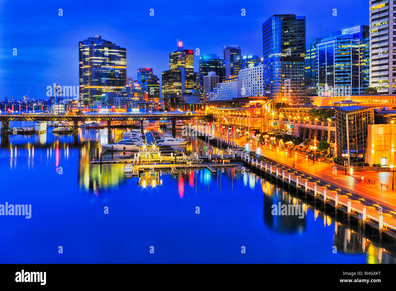 Ora blu intorno al tramonto di Sydney CBD della città porto di Darling Harbour con illuminazione brillante di alto ufficio alloggi e torri che riflettono Foto Stock