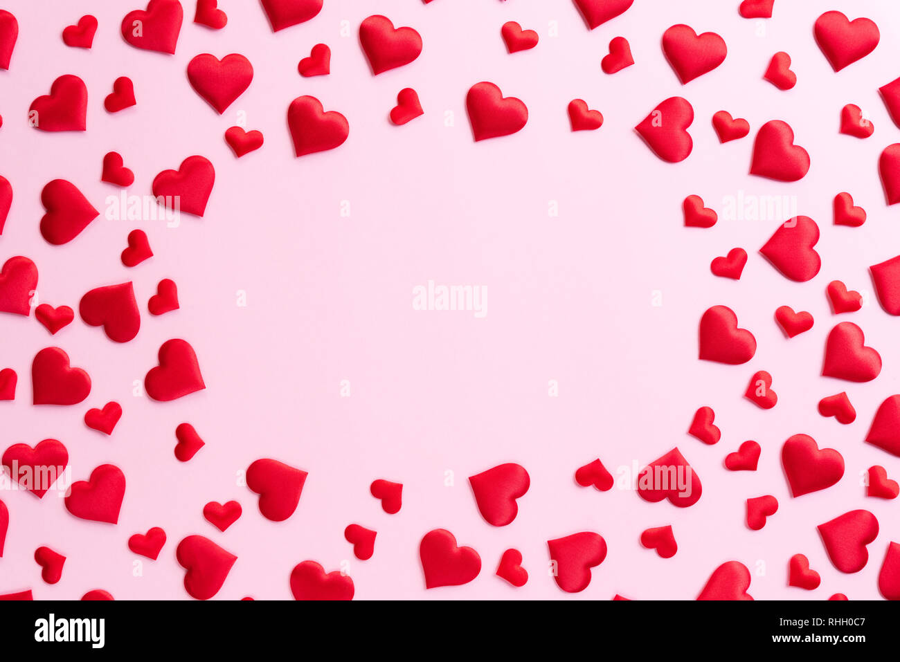 Il giorno di San Valentino e il concetto di amore. Cuori rossi su sfondo rosa. Foto Stock