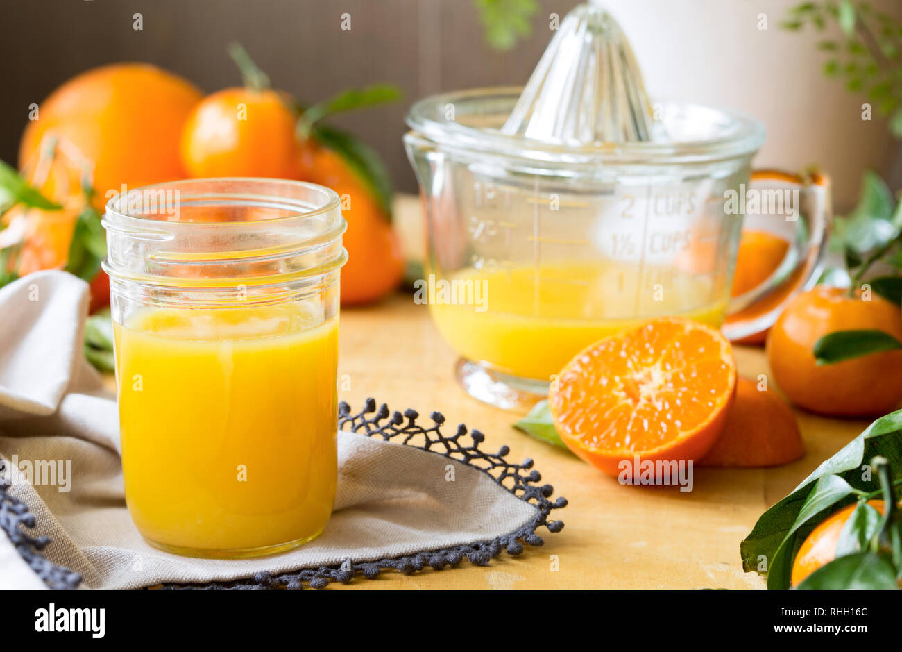 Bicchiere di succo di frutta appena spremuto con biancheria e arance Foto Stock