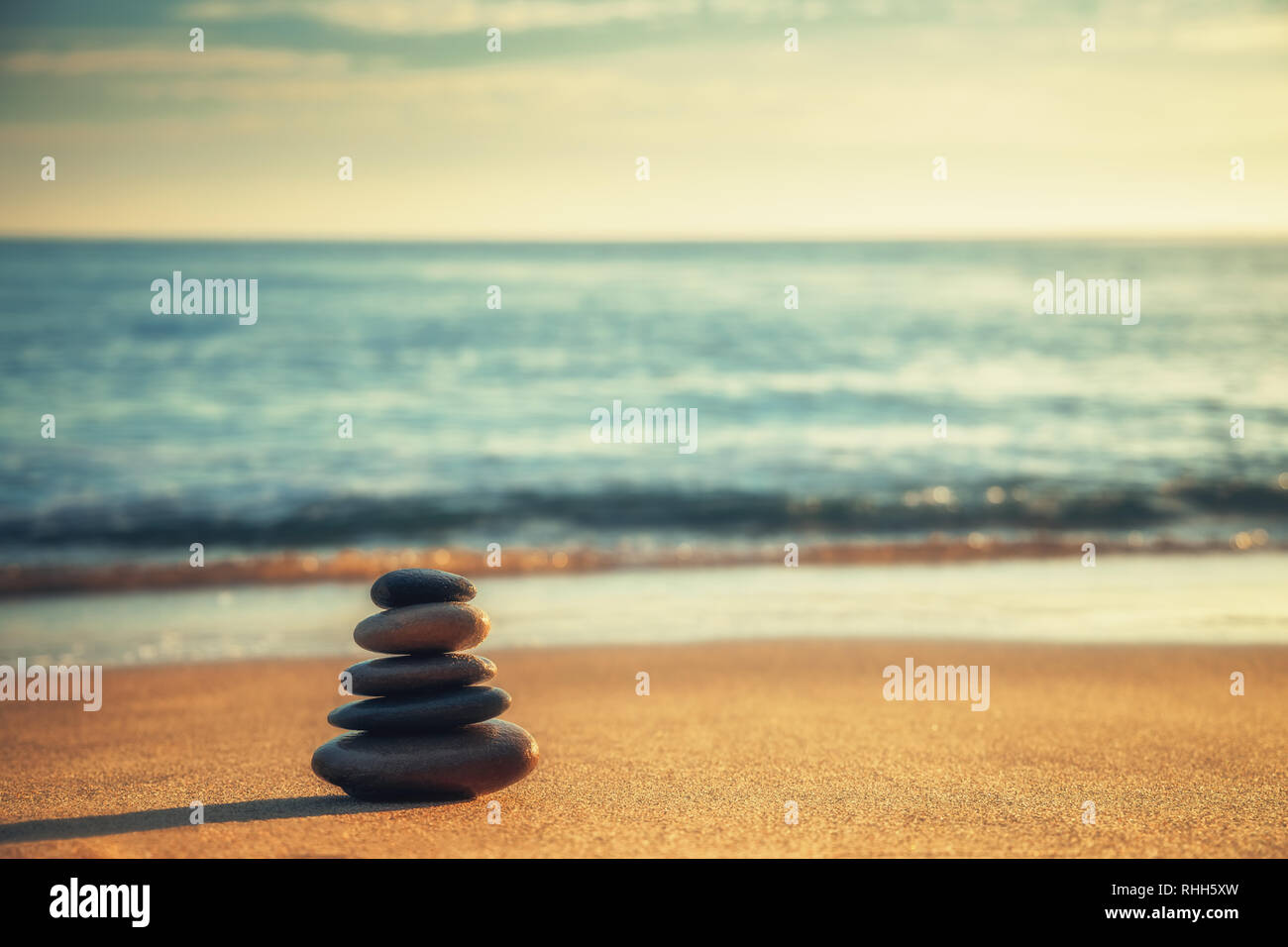Equilibrio di pietre sulla spiaggia, sunrise shot Foto Stock