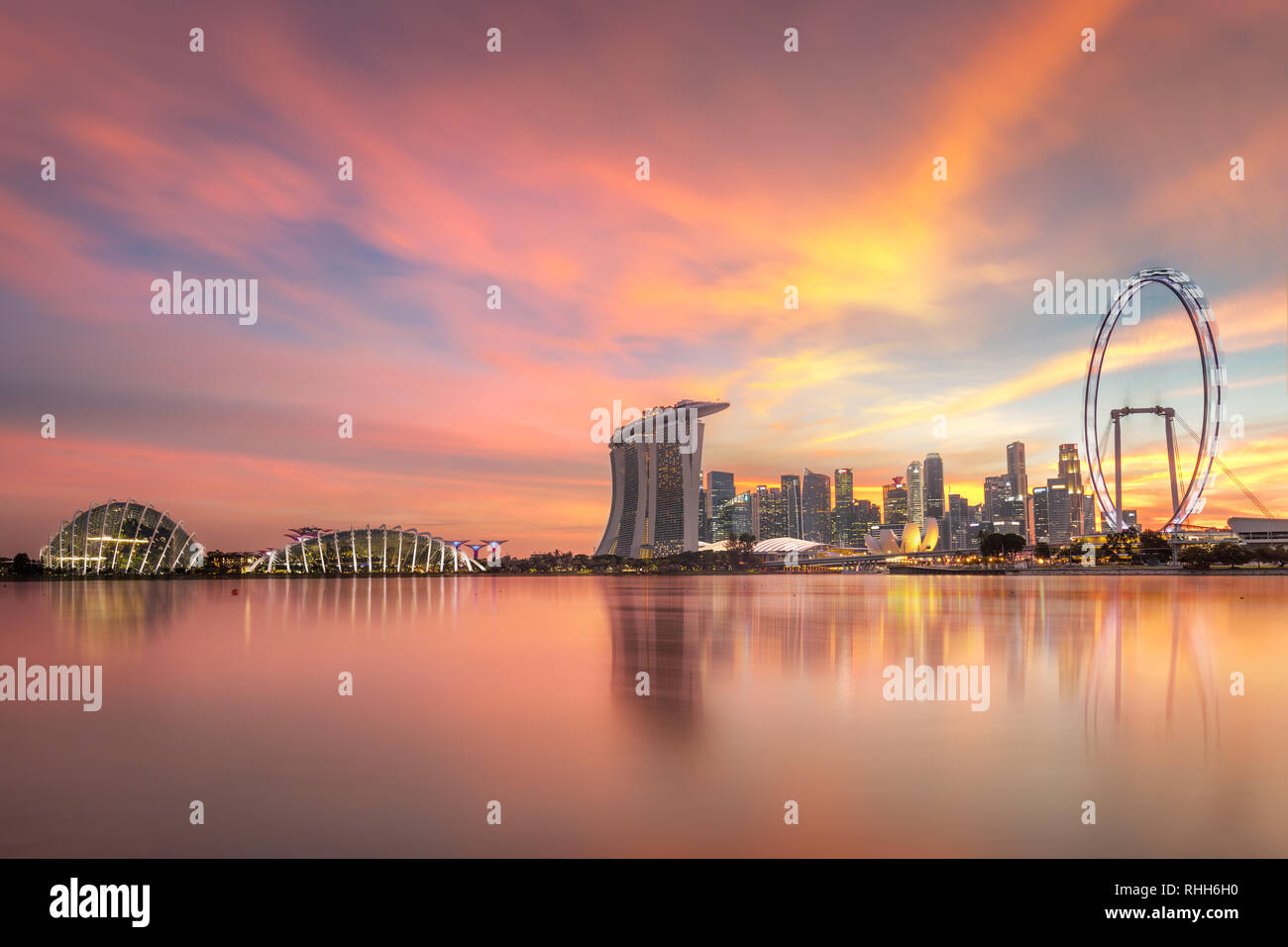 Splendido skyline di Singapore con luminarie. Singapore il distretto commerciale, marina bay sabbia e il giardino dalla baia sul tramonto. Foto Stock