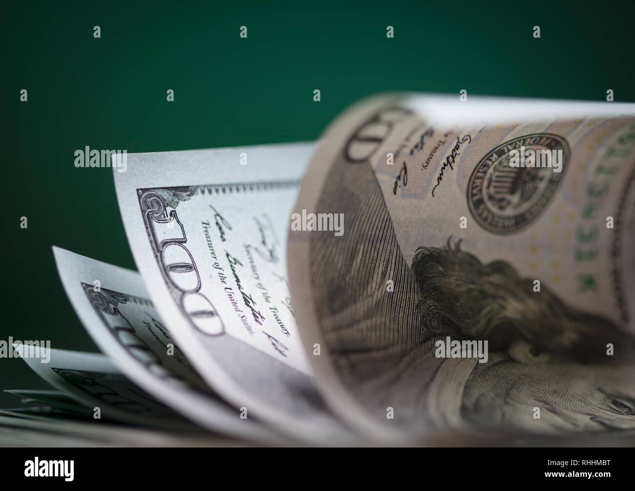 Pila di un centinaio di dollari su sfondo verde Foto Stock