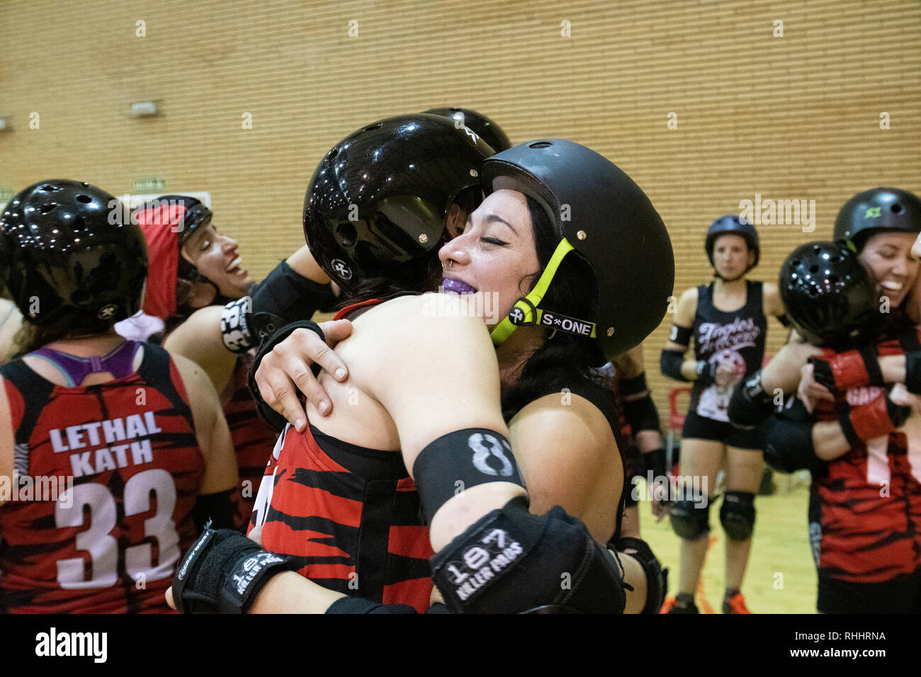 Madrid, Spagna. 2 febbraio 2019. I giocatori di Roller Derby a Madrid (rosso) e Barcellona Roller Derby A (nero) huging e congratularci gli uni con gli altri alla fine del gioco. © Valentin Sama-Rojo/Alamy Live News. Foto Stock