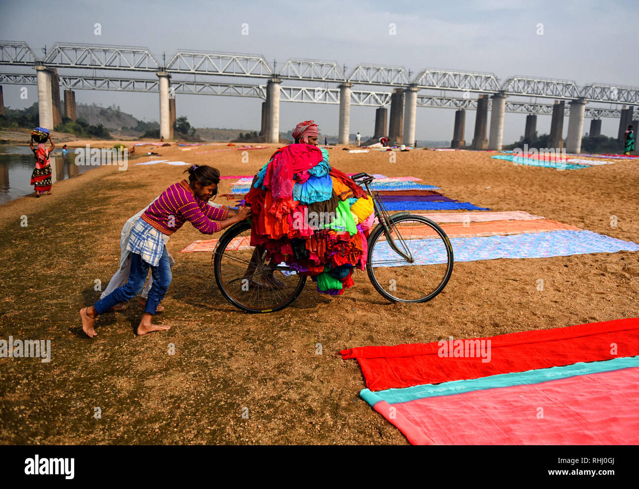 Kumardubi, nello stato del Jharkhand (India). 5 Dic, 2018. I membri della famiglia si vede che si aiutano reciprocamente per portare i vestiti sulla loro bicicletta. Dhobi e le loro famiglie sono coinvolgere direttamente nelle attività di lavaggio attraverso l'anno. Quasi mille famiglie sono coinvolgere direttamente in questo commercio, dopo il lavaggio sono tenendo fuori i vestiti per i negozi per lucidatura e imballaggio. Il Dhobi Ghat (lavaggio massa) di Kumardubi nella provincia Jharkhand è il più grande al mondo. Credito: Avishek Das/SOPA Immagini/ZUMA filo/Alamy Live News Foto Stock