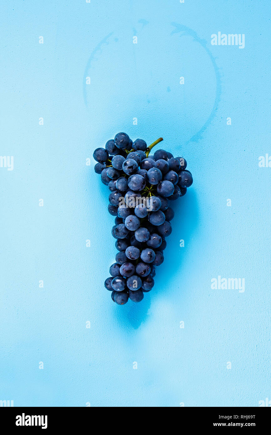 Lay piatto di uva fresca su sfondo blu Foto Stock
