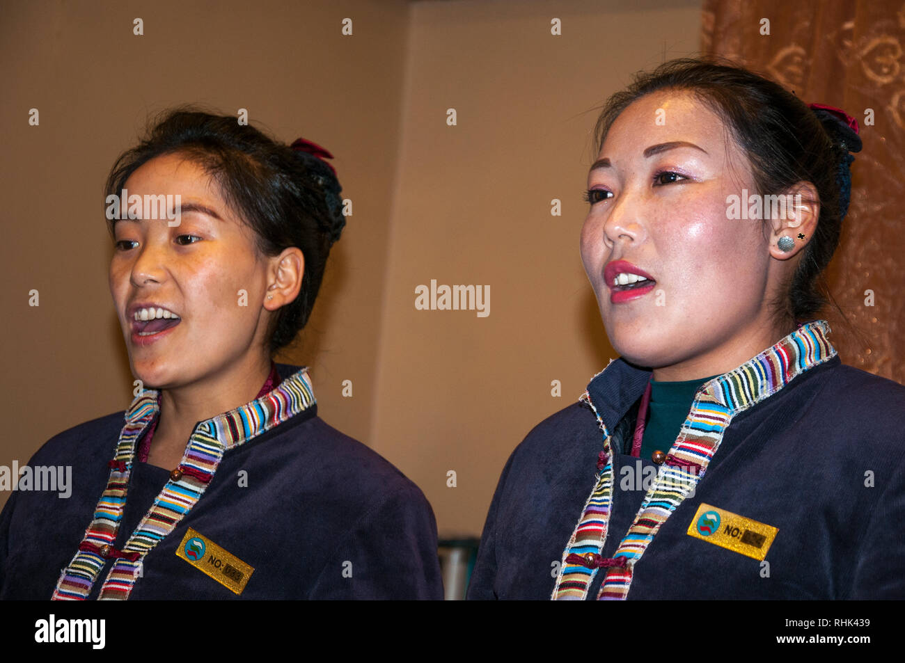 Personale femminile canta per gli ospiti presso un ristorante tibetano, Lhasa, in Tibet, in Cina Foto Stock