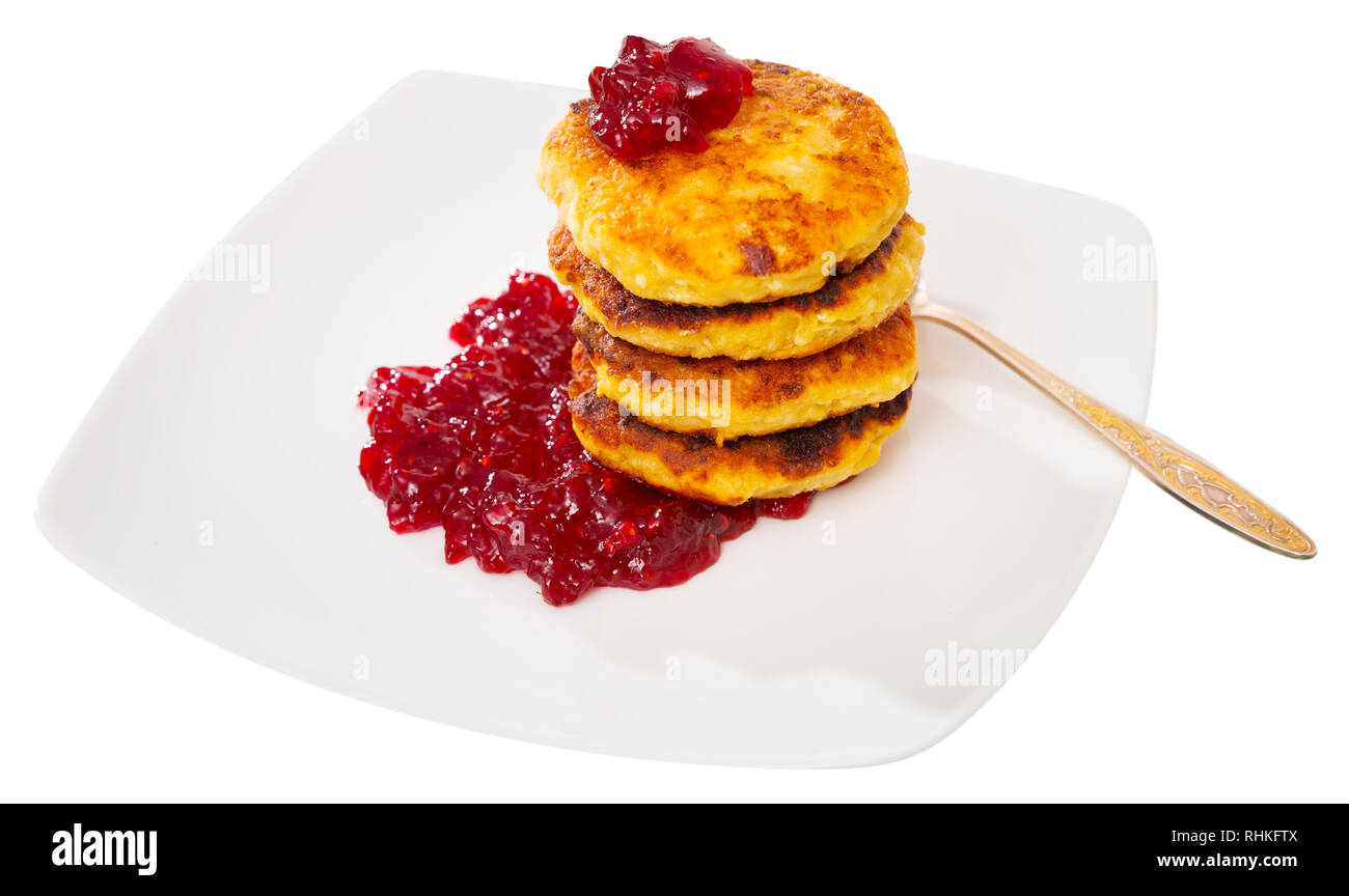 Pila di gustosi piatti fritti frittelle di quark servita con marmellata di frutti di bosco in corrispondenza della piastra. Isolato su sfondo bianco Foto Stock