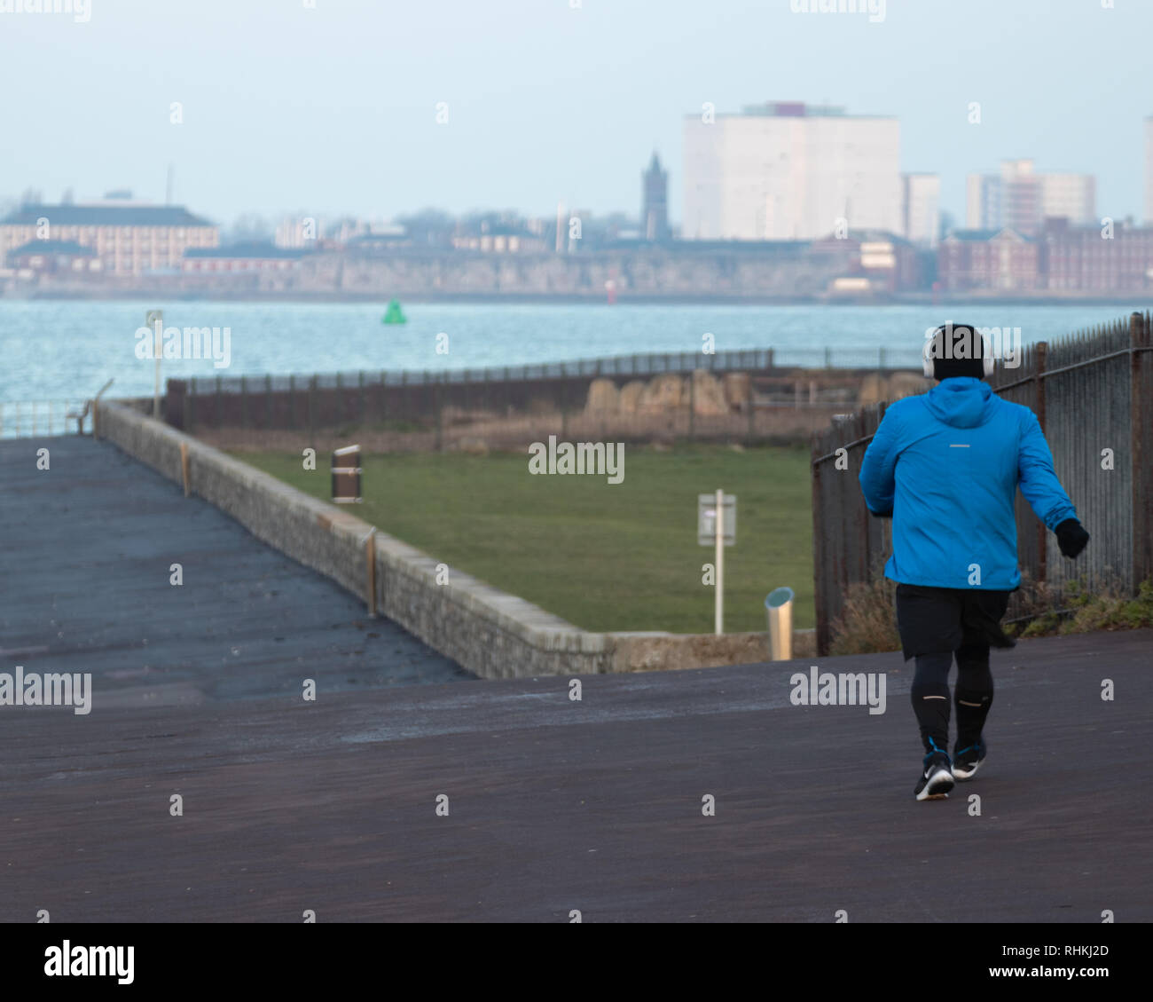 Un uomo di potere camminare lungo la spiaggia su una mattina di inverno Foto Stock