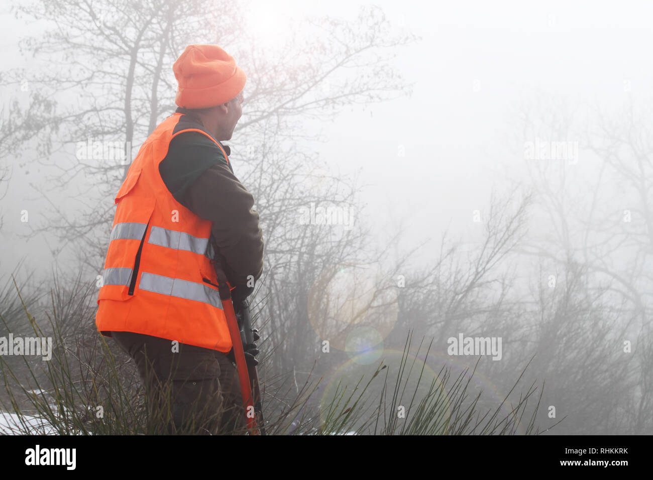 Cacciatore con alta visibilità abbigliamento e fucile, attesa per la caccia  al cinghiale nella campagna di nebbia. Concetto di suoneria Foto stock -  Alamy