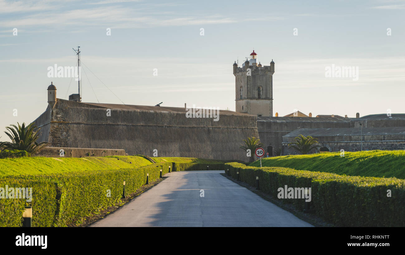 Saint Julian Fortezza (Forte de Sao Juliao da Barra) ingresso con giardino verde, tower e del faro, strada con Tony lampioni, Oeiras, Lisbona Foto Stock