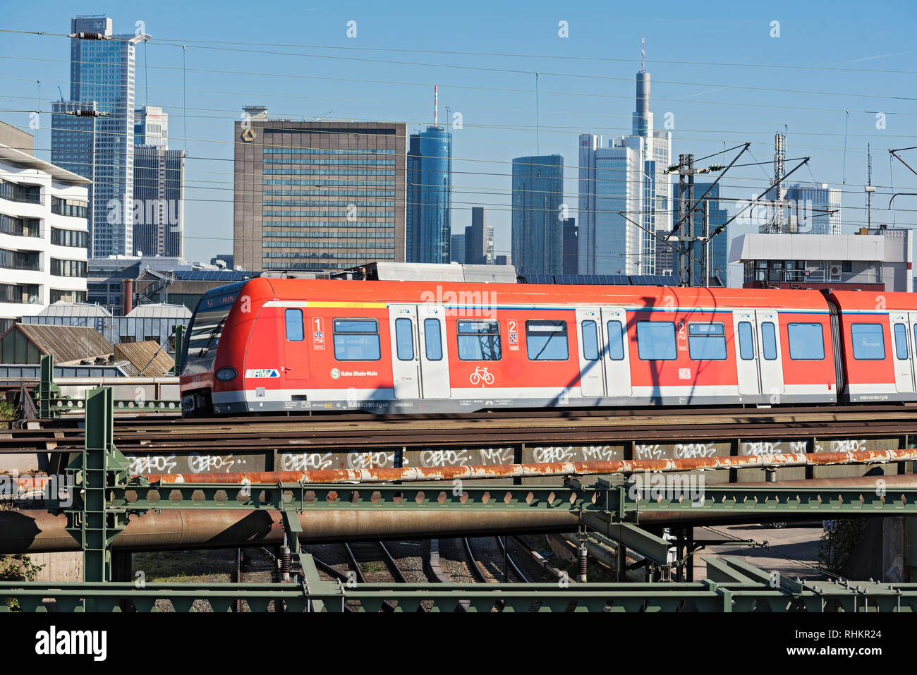 Un rosso treno regionale del reno di traffico principale nella parte anteriore della skyline di Francoforte sul Meno, Germania Foto Stock