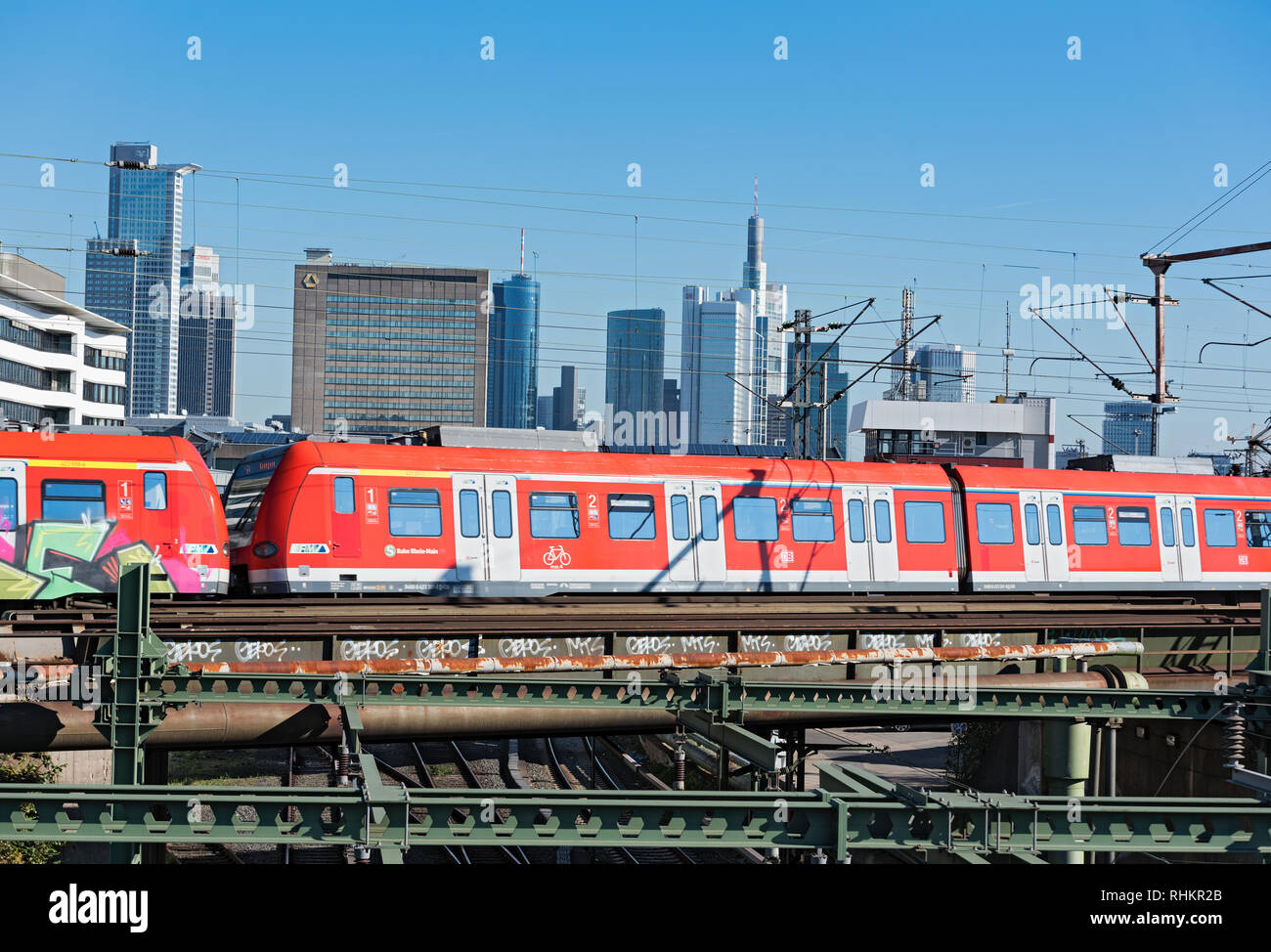 Un rosso treno regionale del reno di traffico principale nella parte anteriore della skyline di Francoforte sul Meno, Germania Foto Stock