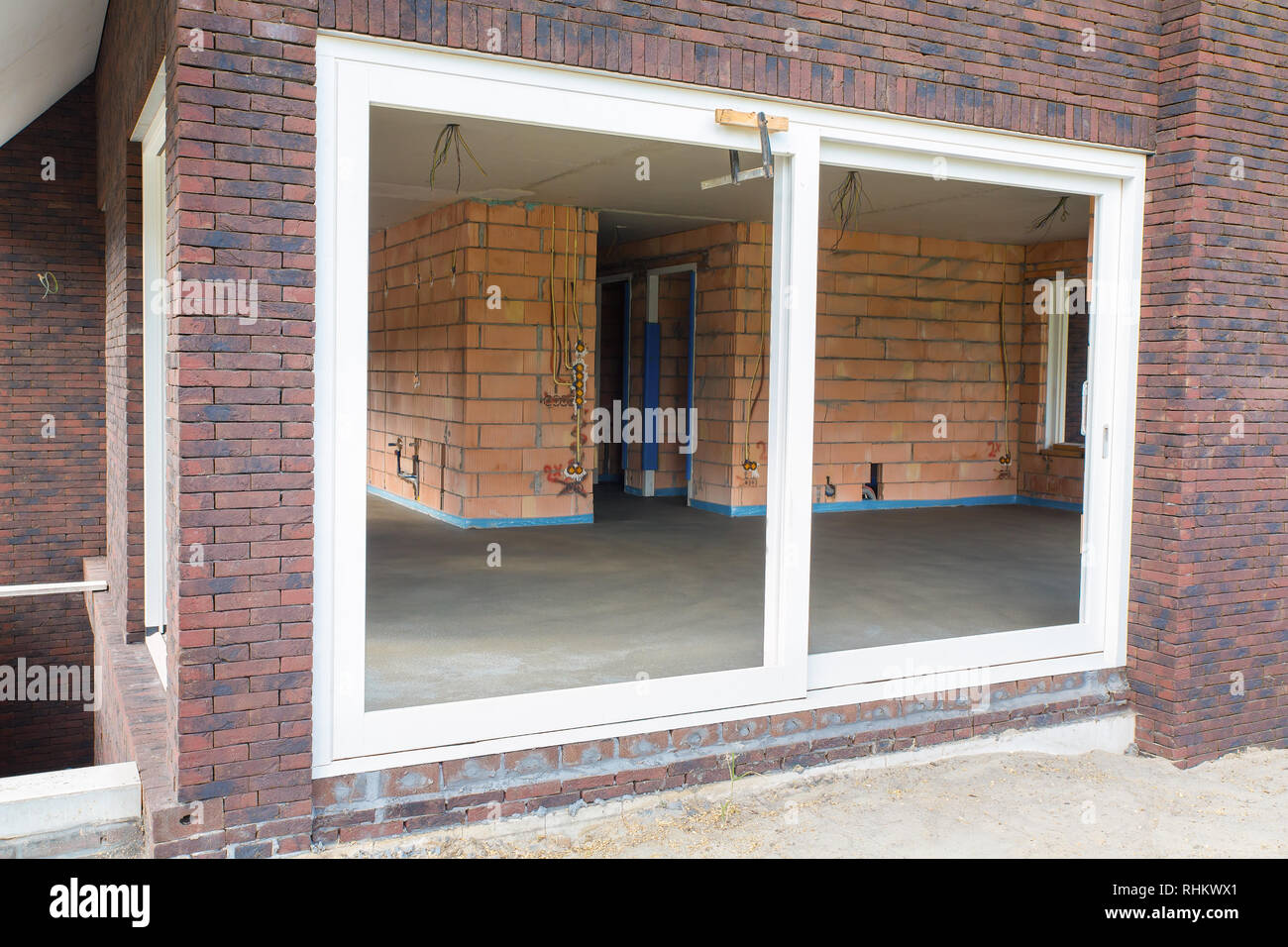 La facciata della casa di nuova costruzione con pavimento di cemento all'interno Foto Stock