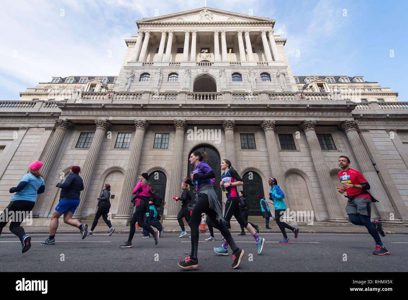 I corridori passano la Bank of England, nella City di Londra, che prendono parte al Cancer Research UK London Inverno Esegui. Foto Stock