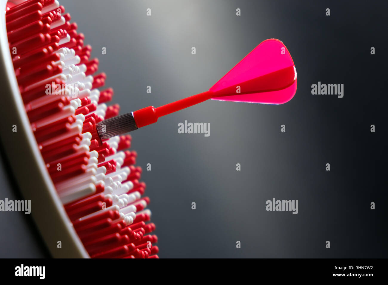 Rosso freccia dart di colpire il centro del dartboard per il raggiungimento degli obiettivi concettuali Foto Stock