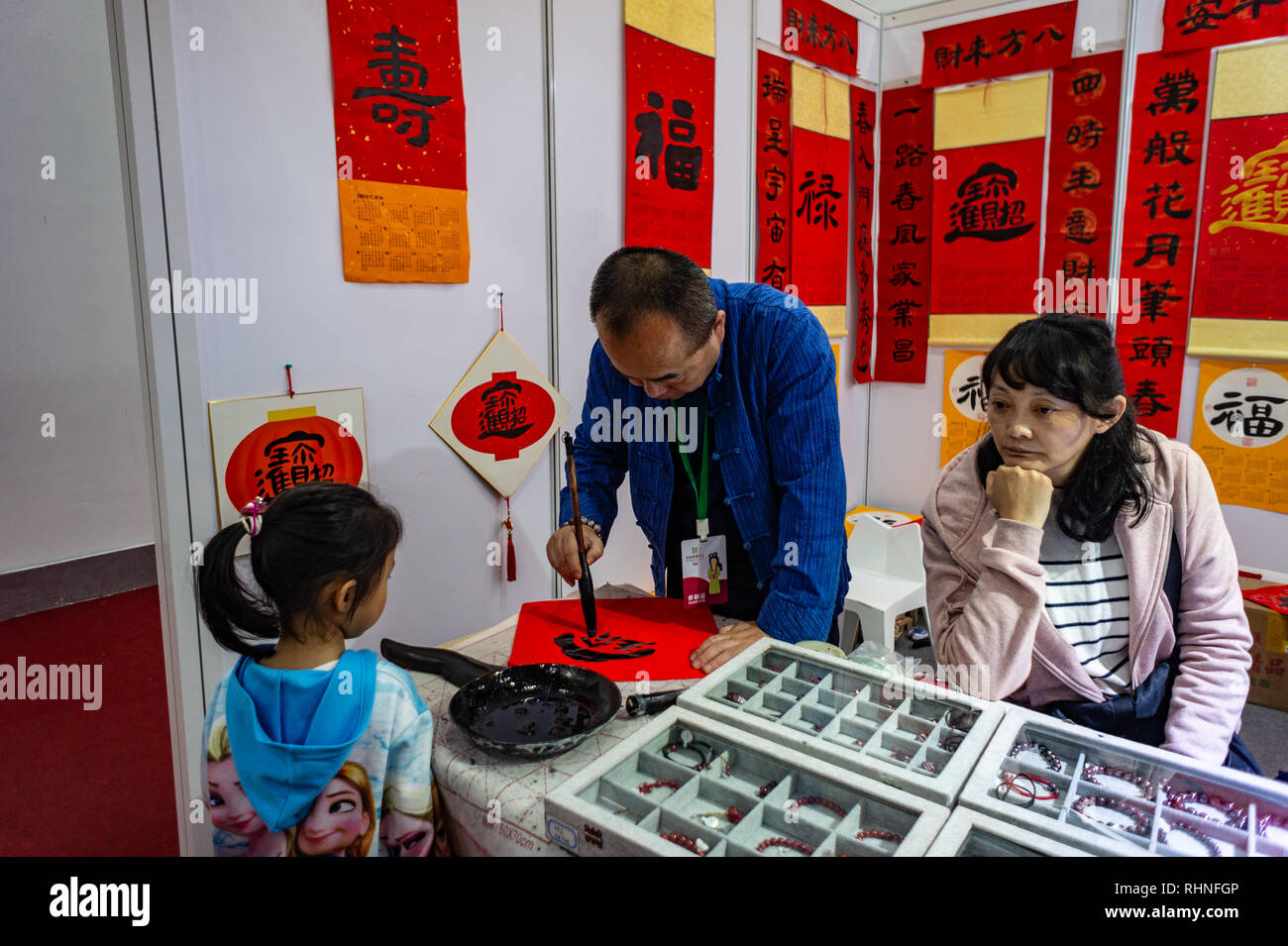 Ragazza orologi uomo artista disegna la calligrafia cinese di Shenzhen, Cina. Foto Stock