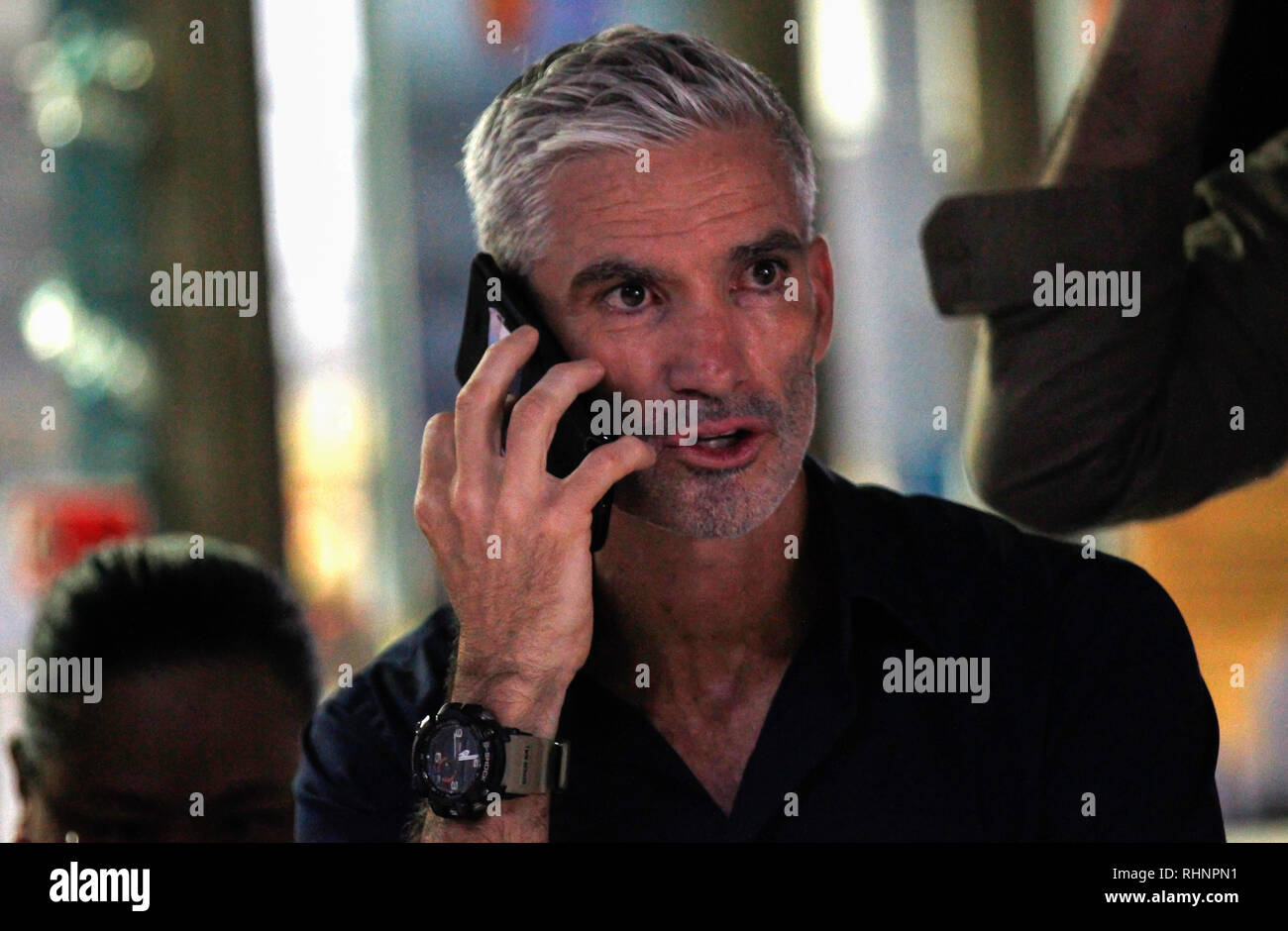 Ex Australian soccer team nazionale stati Craig Foster colloqui sul suo telefono cellulare come arriva a sostegno di detenuti Bahraini giocatore di calcio Hakeem al-Araibi presso il tribunale penale di Bangkok. Foto Stock