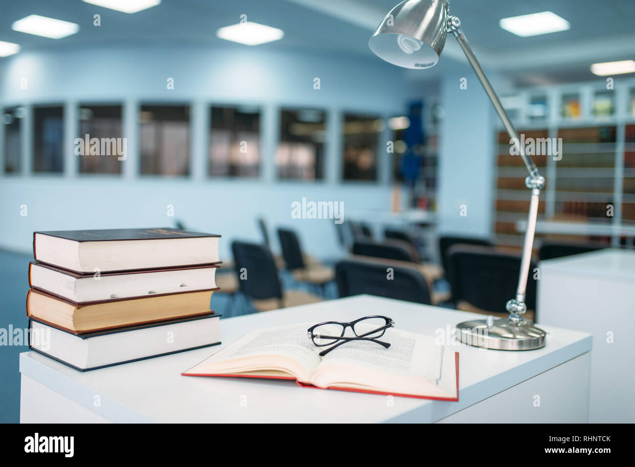 Pila di libri e i bicchieri sul tavolo della biblioteca universitaria, nessuno. Conoscenza depositario, il concetto di istruzione Foto Stock