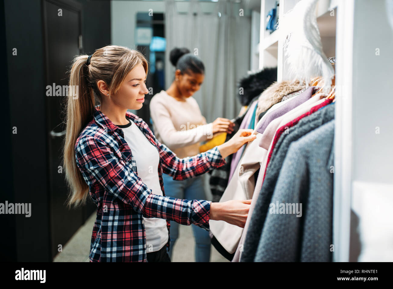 Due amiche scegliendo i vestiti, shopping. Gli appassionati di shopping nel  negozio di abbigliamento, il consumismo lifestyle, moda Foto stock - Alamy