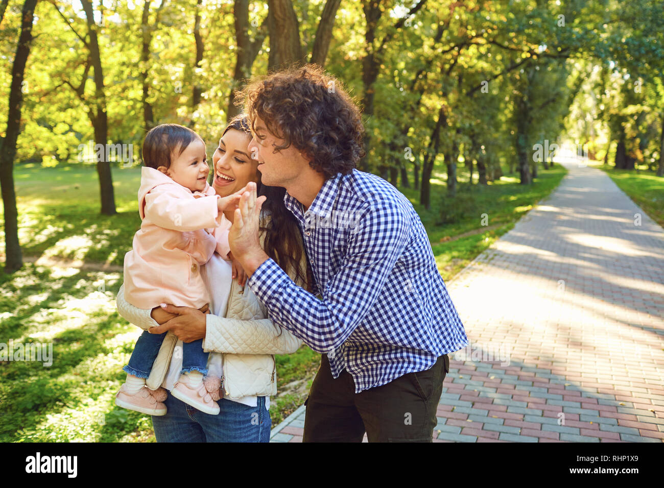 La famiglia felice in piedi a giocare nel parco. Foto Stock