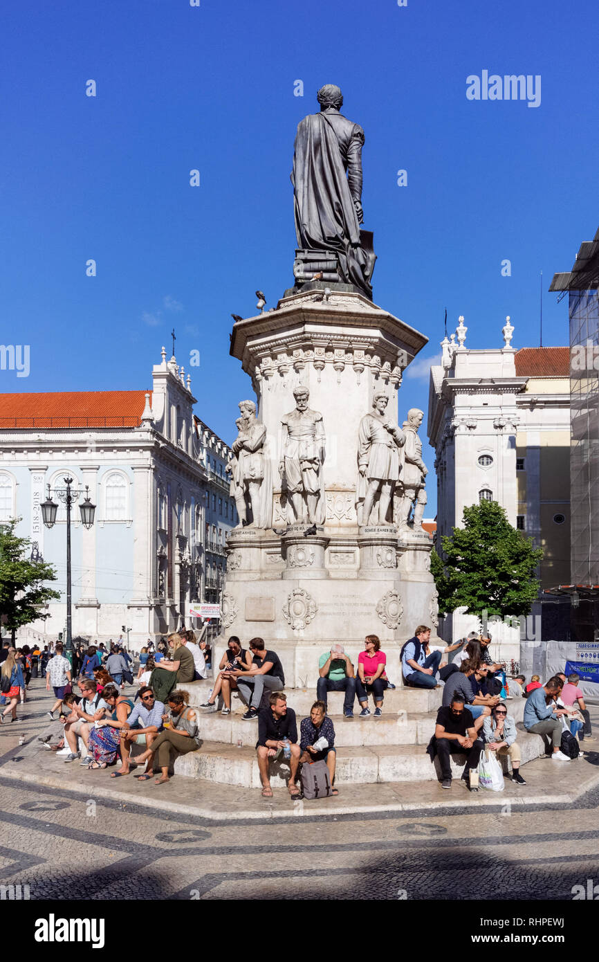 Turisti che si siedono attorno al Luís de Camões statua a Praça Luís de Camões di Lisbona, Portogallo Foto Stock