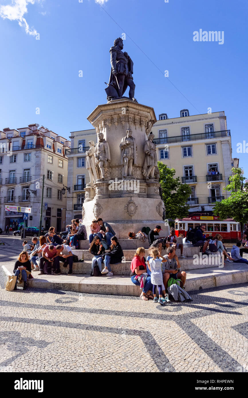 Turisti che si siedono attorno al Luís de Camões statua a Praça Luís de Camões di Lisbona, Portogallo Foto Stock