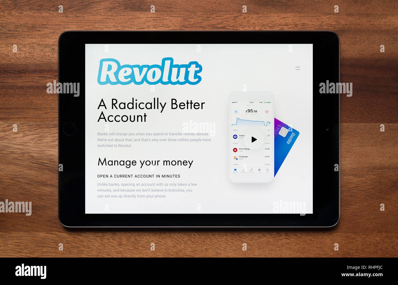 Il sito web di Revolut è visto su un tablet iPad, il quale è appoggiato su un tavolo di legno (solo uso editoriale). Foto Stock