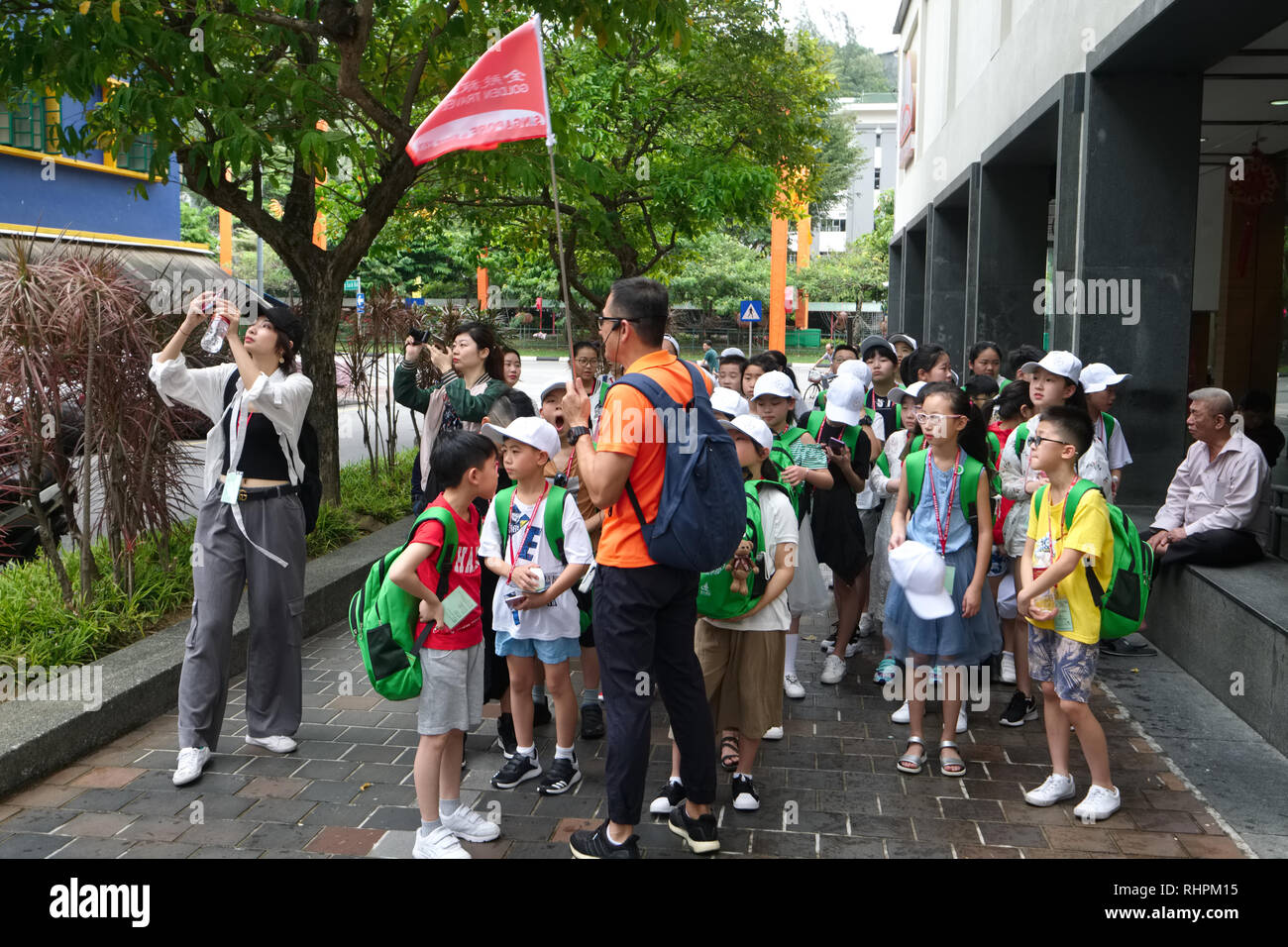 Un tour guida conduce i giovani visitatori cinesi attraverso Chinatown, Singapore Foto Stock