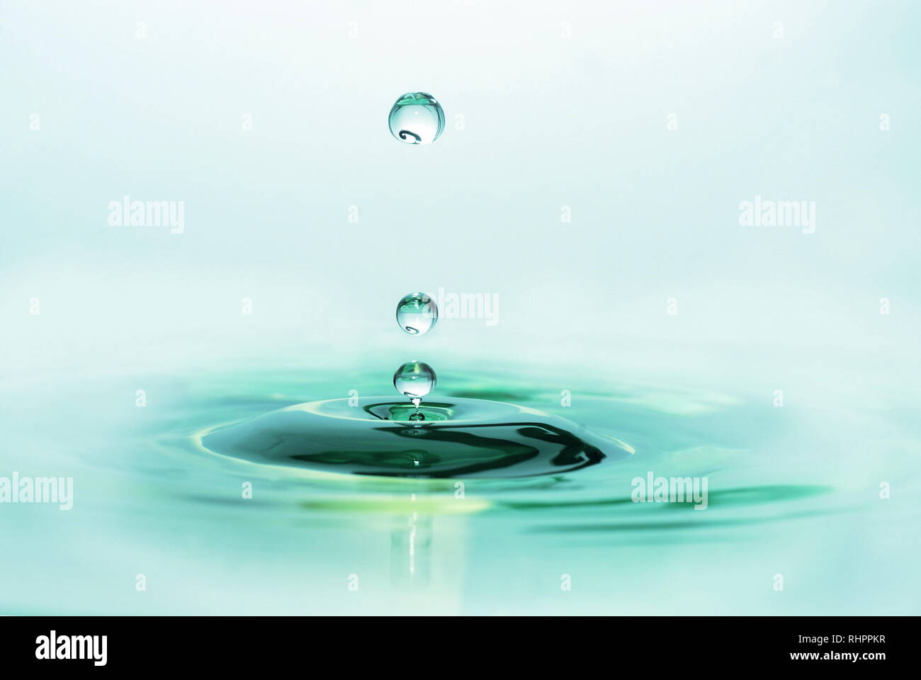 Calmo e rilassante verde-blu caduta di acqua splash con helix riflessione Foto Stock