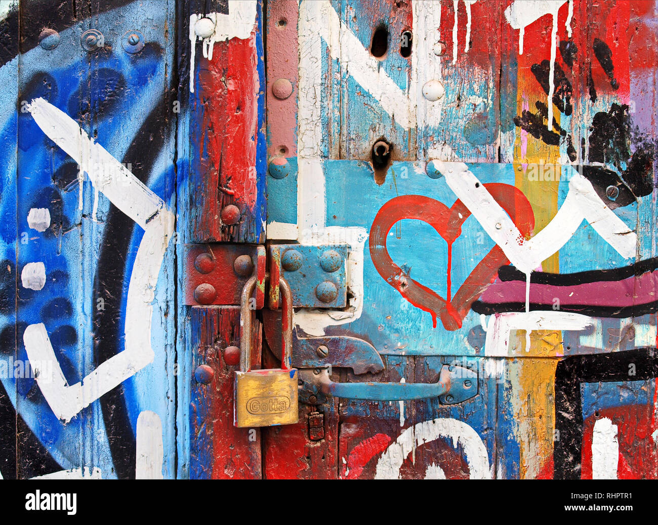 La vibrante i graffiti sulla vecchia porta con serratura Foto Stock