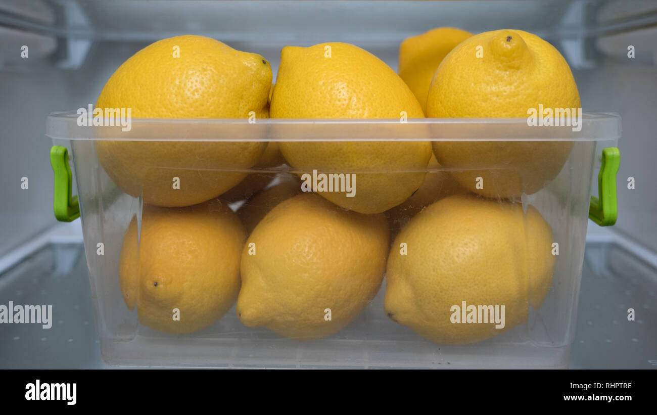 Alimenti biologici sfondo. Cibo sano. Mangiare sano. Dieta. La vitamina C. frutta fresca. Il bar e il concetto reastaurant. Contenitore in plastica con limoni in Foto Stock