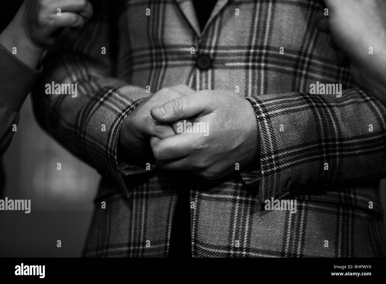 Immagine in bianco e nero con i dettagli delle mani di un politico mentre viene intervistato dalla stampa Foto Stock