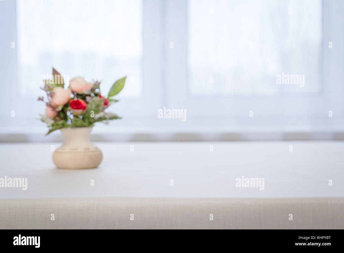 Grande Vaso con rose fiori rossi contro una finestra sfuocata Foto Stock