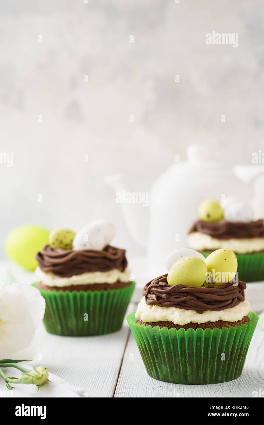 Pasqua tortini di cioccolato decorate con nido e uova di caramelle per dessert. Festosa concetto di pasticceria. Foto Stock