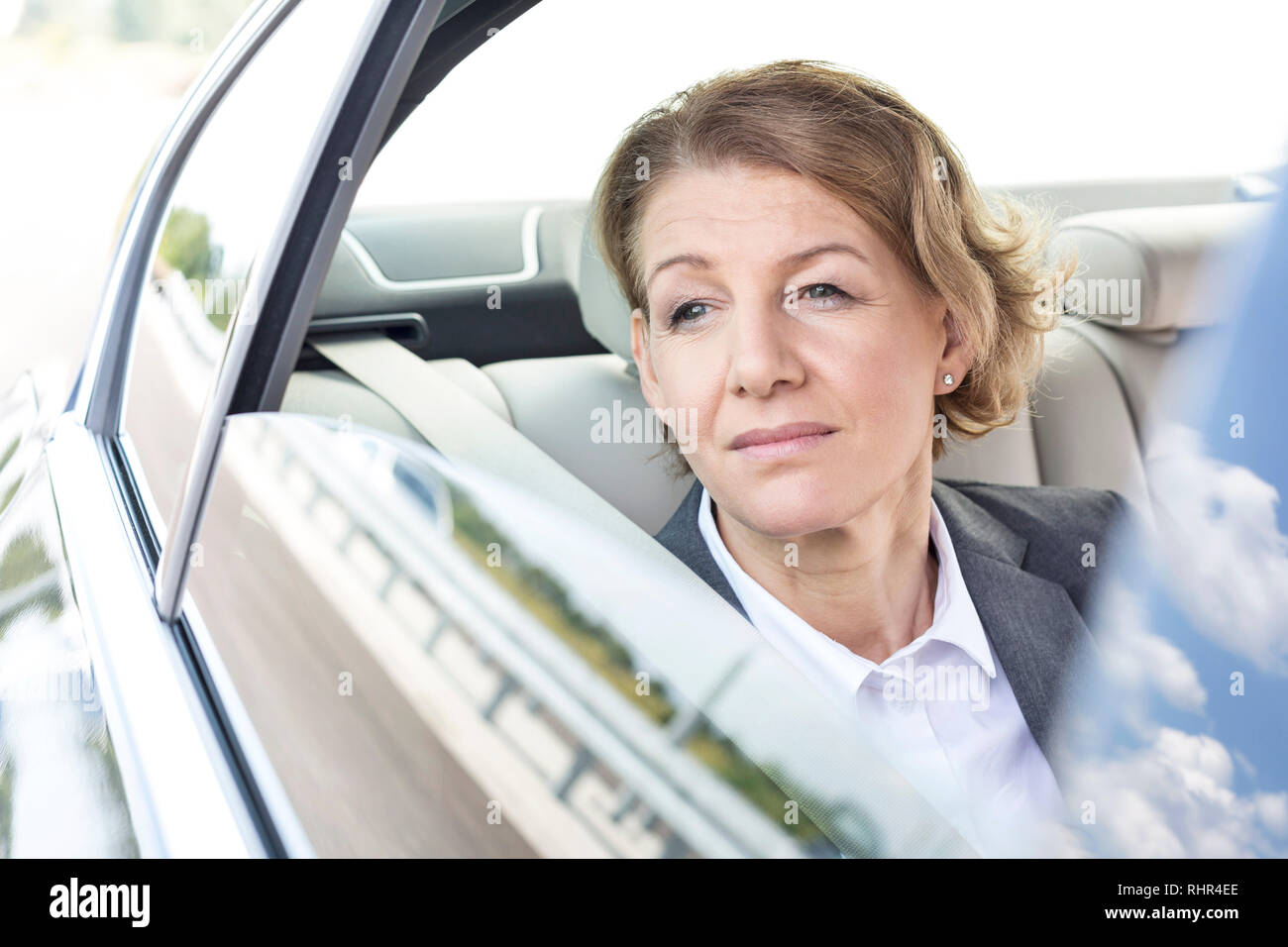Riflessivo imprenditrice guardando attraverso la finestra mentre è seduto in auto Foto Stock