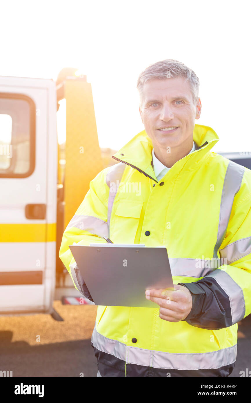 Ritratto di fiducioso carroattrezzi driver con appunti in Abbigliamento riflettivo Foto Stock