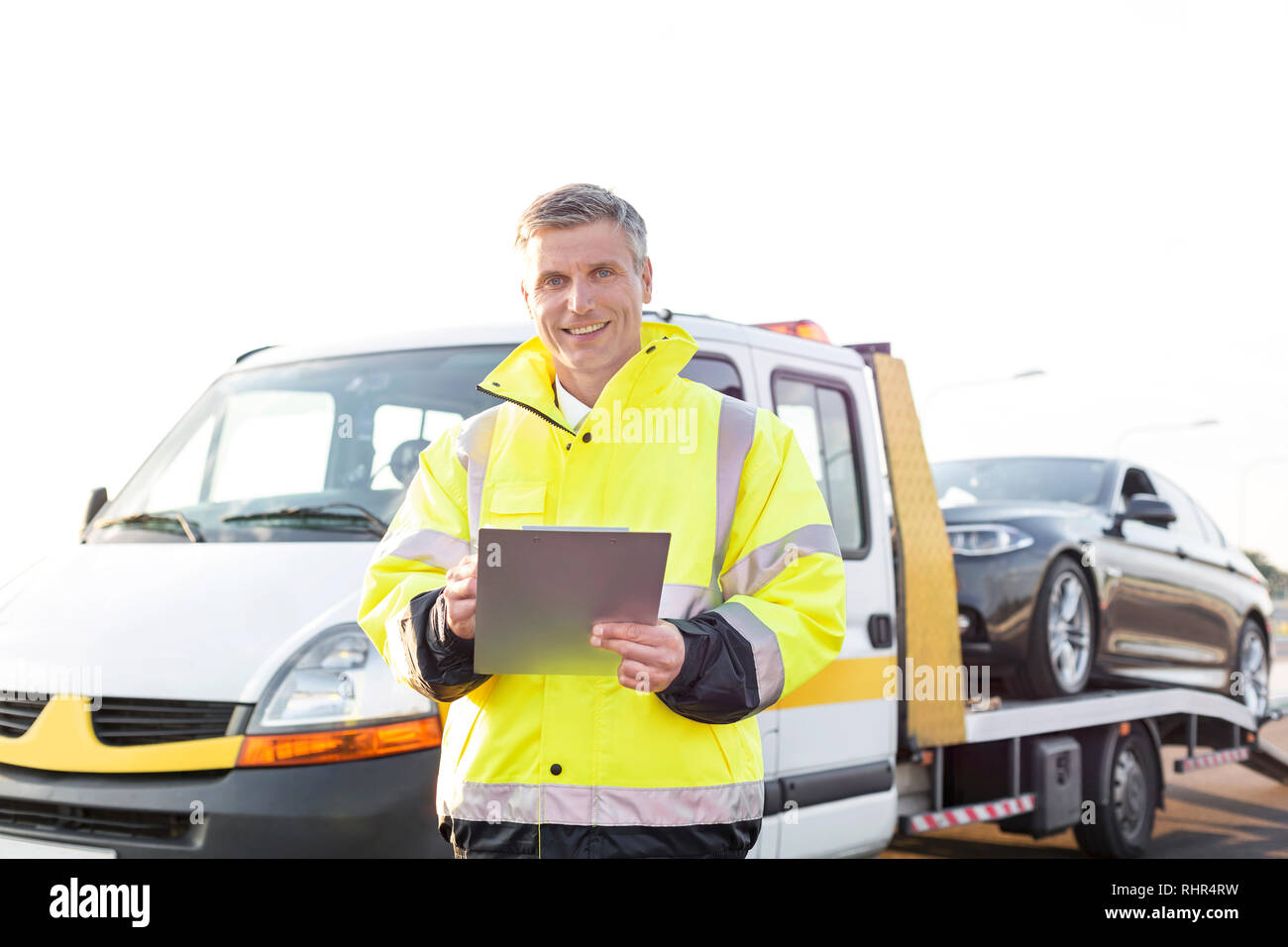 Ritratto di sorridere carroattrezzi driver con appunti contro sky Foto Stock