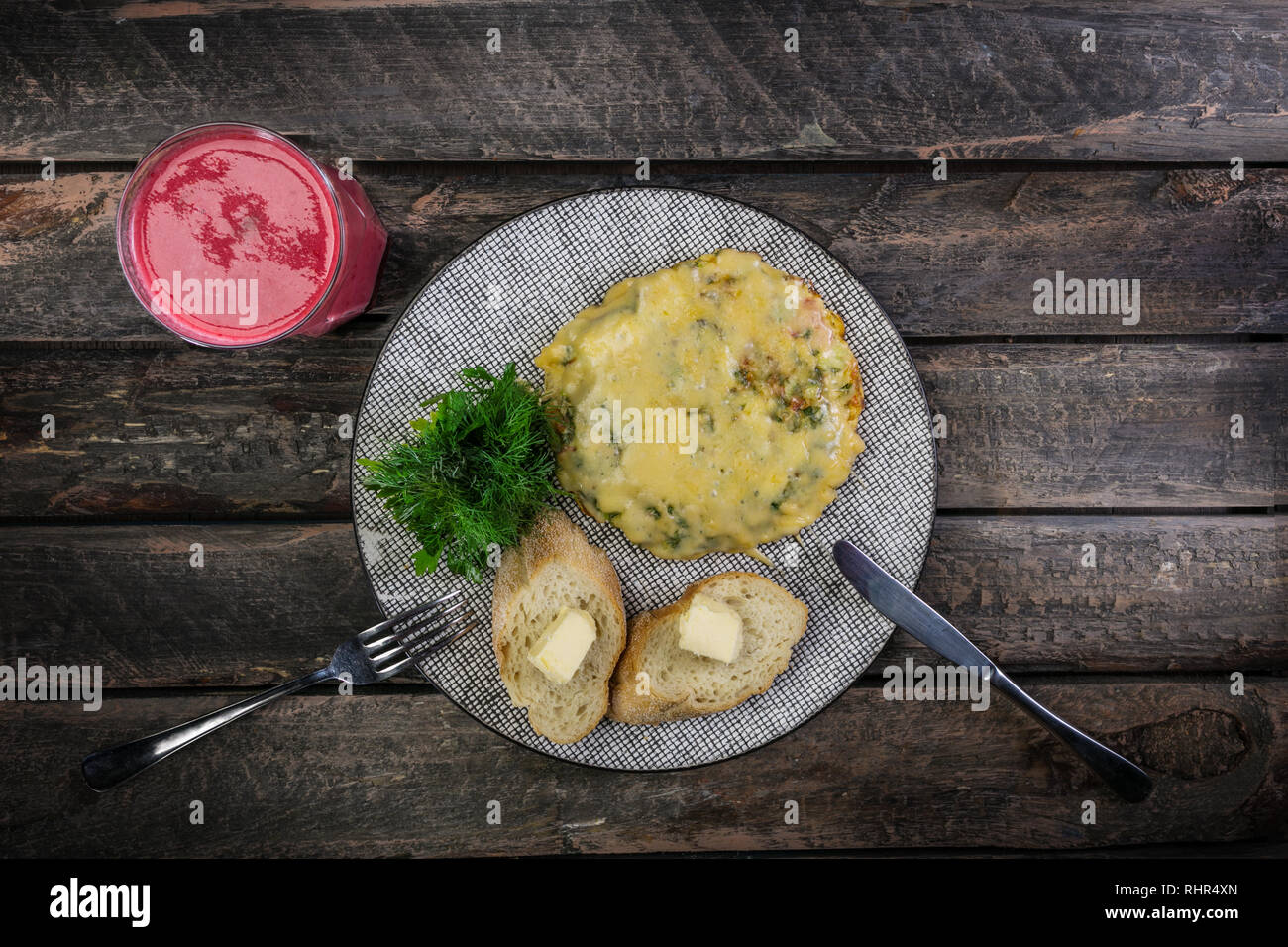Frittata con pomodori, zucchine e funghi serviti da posate e freschi drink di Berry. La frittata prima colazione. Cibo sano. Vista dall'alto. Foto Stock