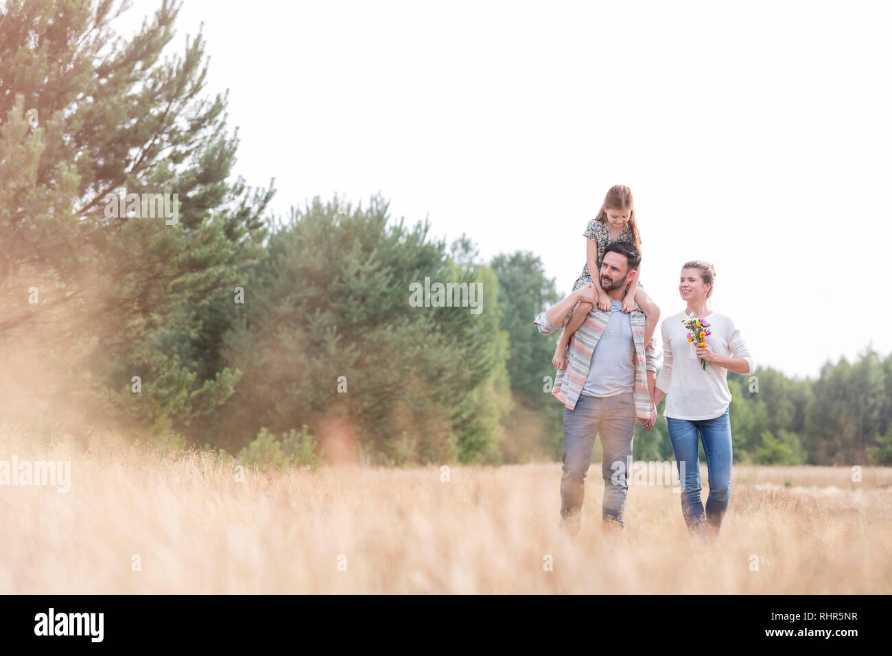 Famiglia camminando sul campo in terreni agricoli Foto Stock